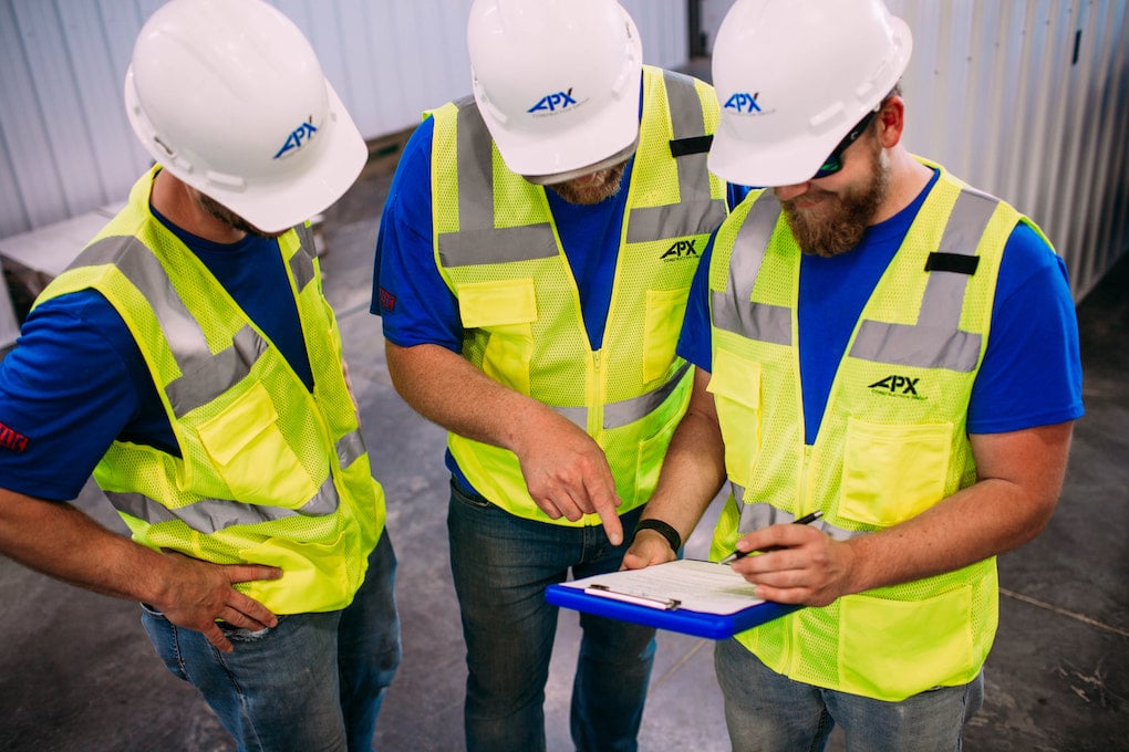 apx workers looking at document on clipboard; warehouse design tips