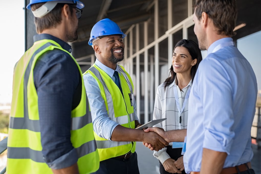 construction workers shaking hands; commercial construction checklist