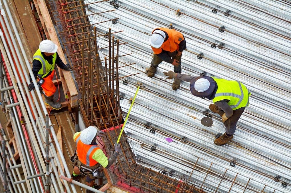 aerial view of workers installing rebar; pre-engineered metal buildings average cost