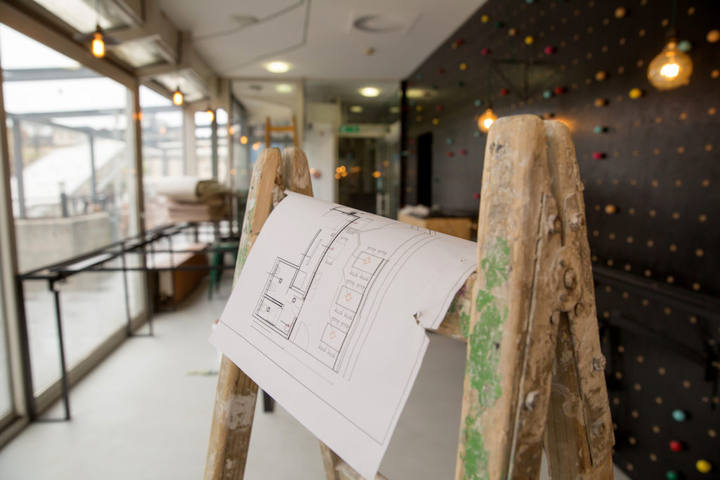 restaurant construction blueprint on a ladder