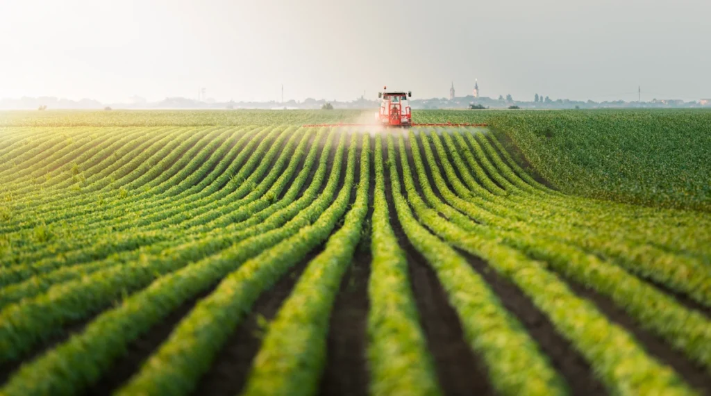 why is agriculture important-tractor in the distance on a field of crops