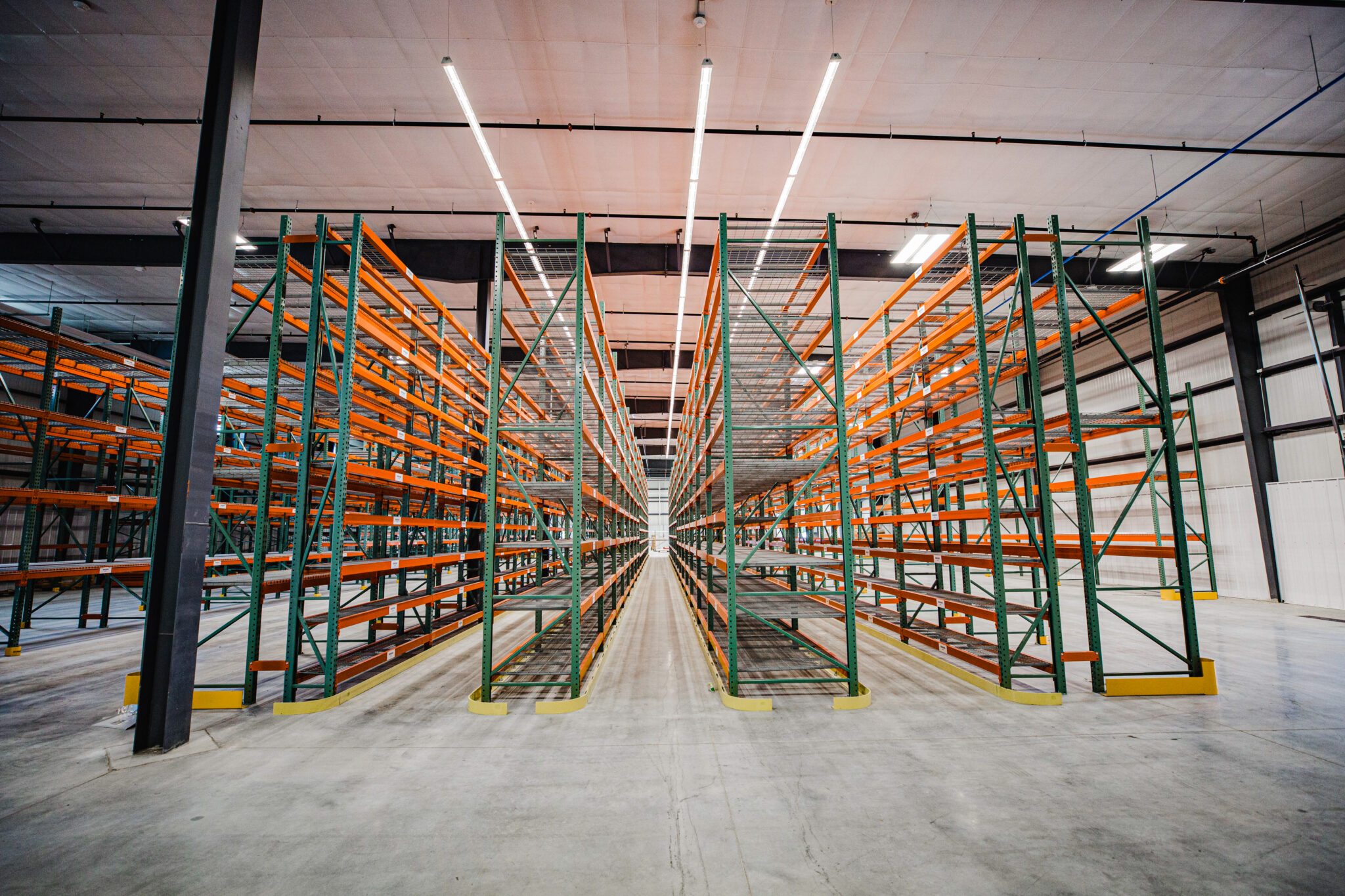 Interior of a warehouse storage facility with tall shelves filled with organized boxes and pallets, showcasing an efficient storage system