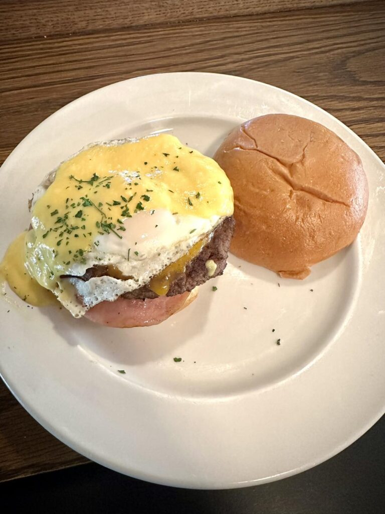 Eggs Benny Burger-angus patty, Canadian bacon, cheddar cheese, hollandaise and basted egg
